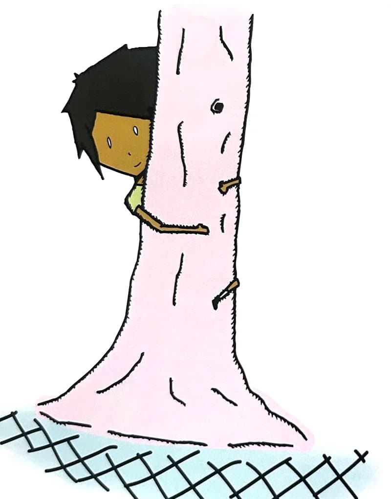 A boy peeks out from behind a tall tree trunk.